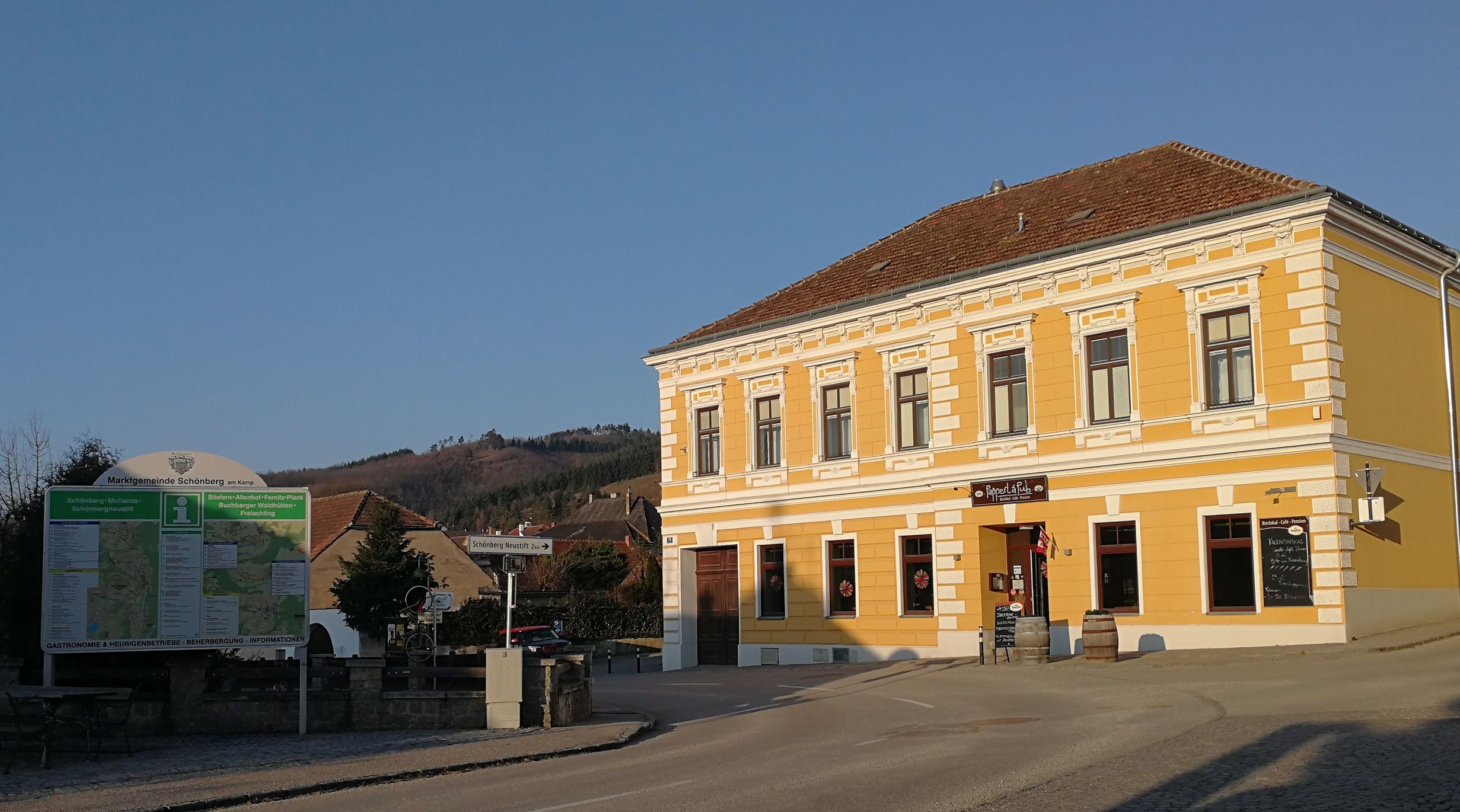 Gelbes Gebäude mit Schild 'Papperl á Pub' in Schönberg am Kamp, Österreich.