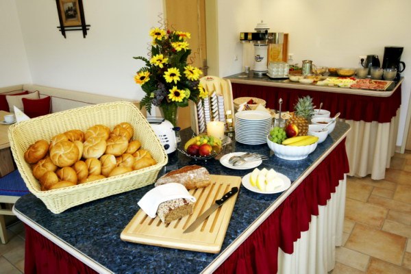 Fr&uuml;hst&uuml;cksbuffet mit Br&ouml;tchen, Obst und Blumen.
